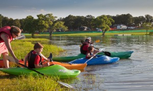 family kayaking on lake