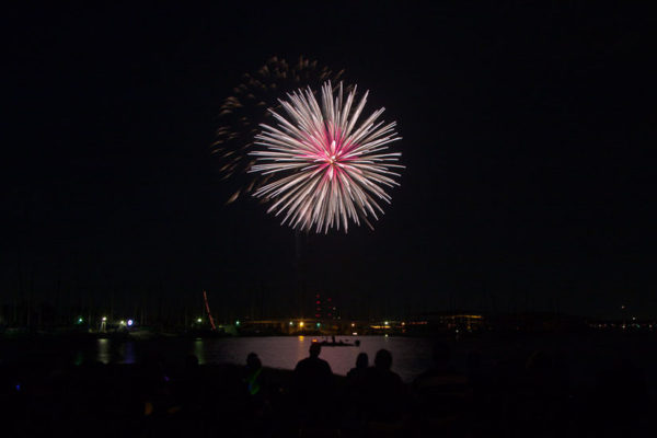 fireworks exploding over lake